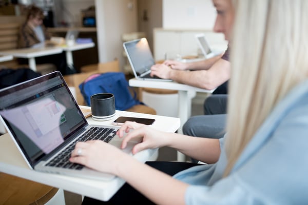 learners engaging in online training in front of laptops